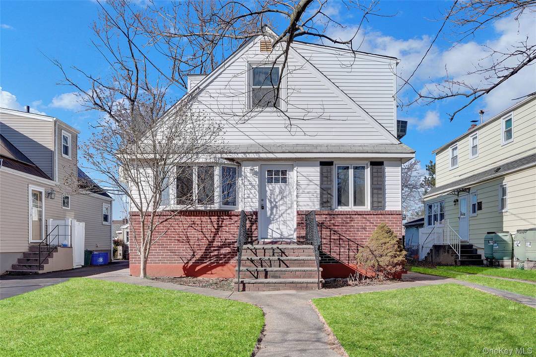 Expanded Cape style home featuring 4 bedrooms, 2 full baths, a formal dining room, an eat in kitchen, and a 1 car garage.
