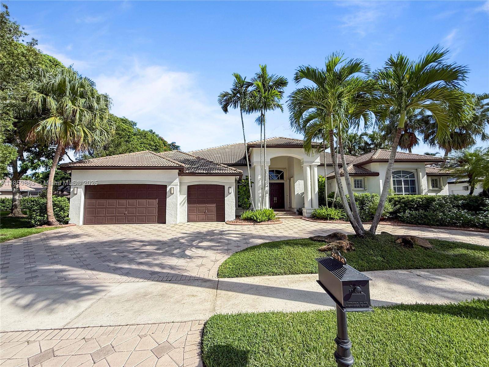 Welcome Home ! This spectacular residence, boasting a lake and golf course view, is perfectly situated in the prestigious Poinciana enclave of Weston Hills Country Club.