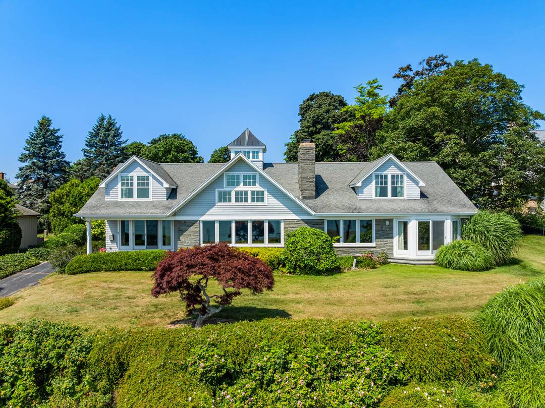 An enchanting New England home situated atop lush lawns with expansive panoramic water views overlooking a pageantry of sunrises, the beach, ocean views, sailboats, sea, sand, and iconic lighthouses with ...