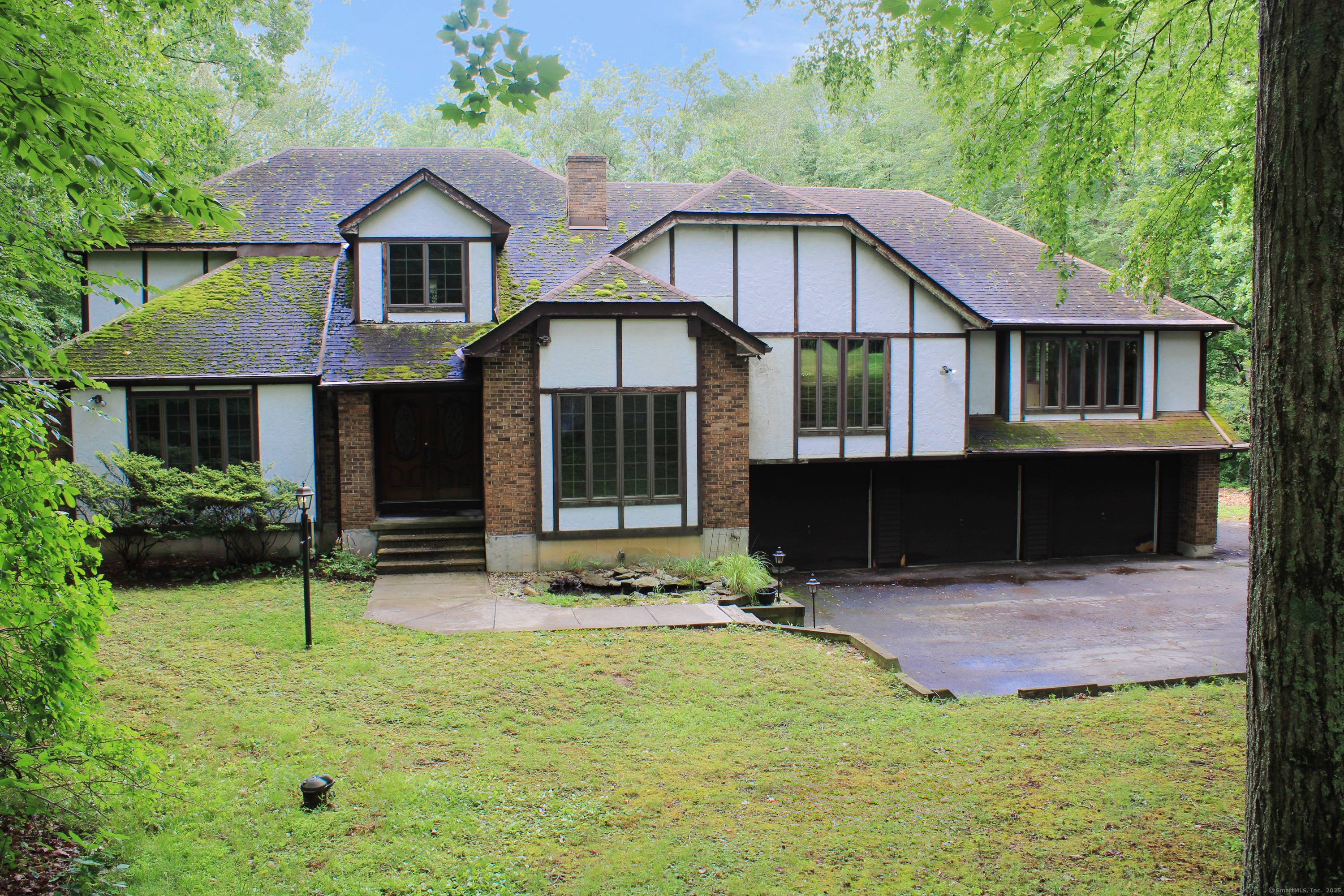 Private wooded setting, multi level Tudor Style home on 2.