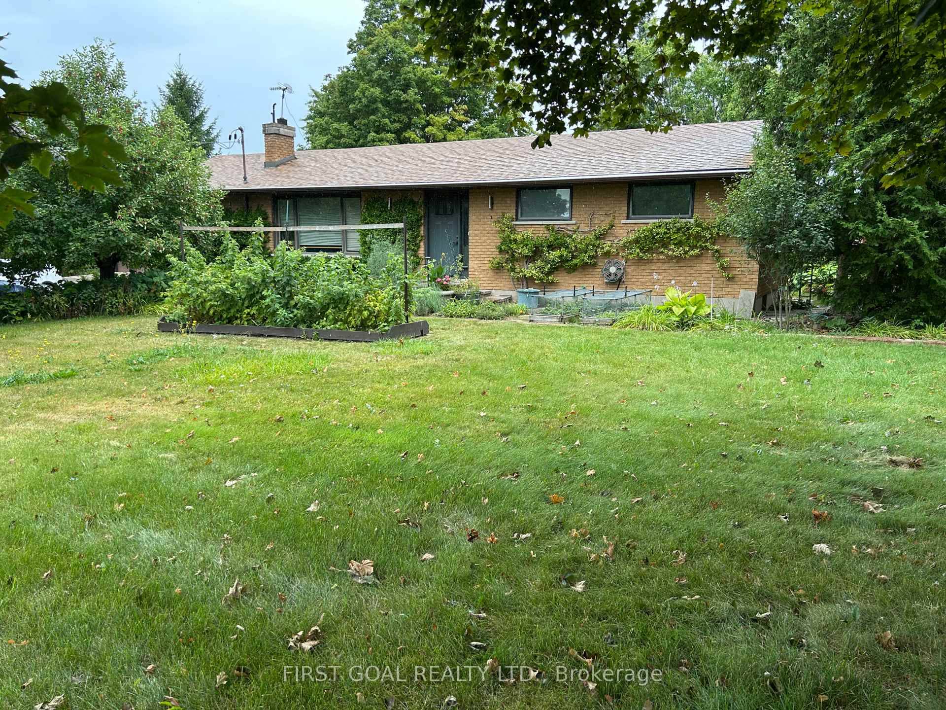 This charming brick bungalow is nestled in a beautiful country setting, surrounded by lush gardens and a serene pond.