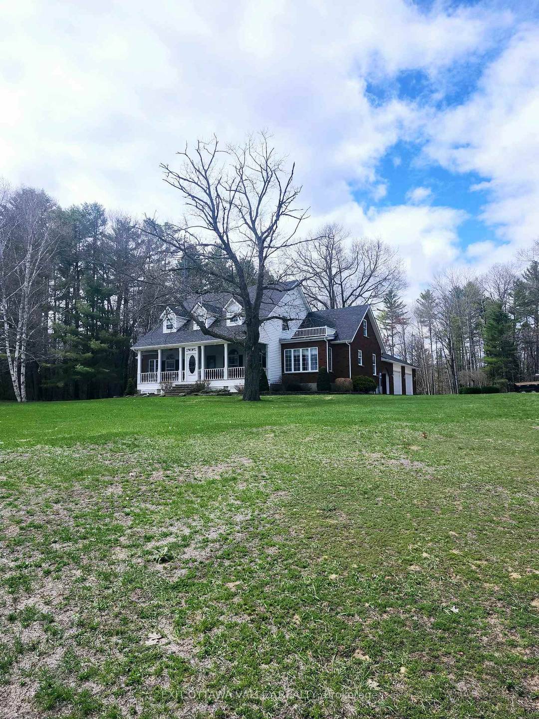 A rustic lane leads to a private place with open fields surrounded by mature trees with a grand home perched on a hill.