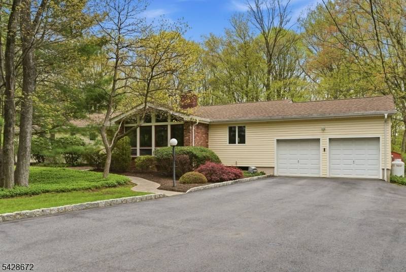 Welcome home to this desirable ranch set on a serene, wooded lot.