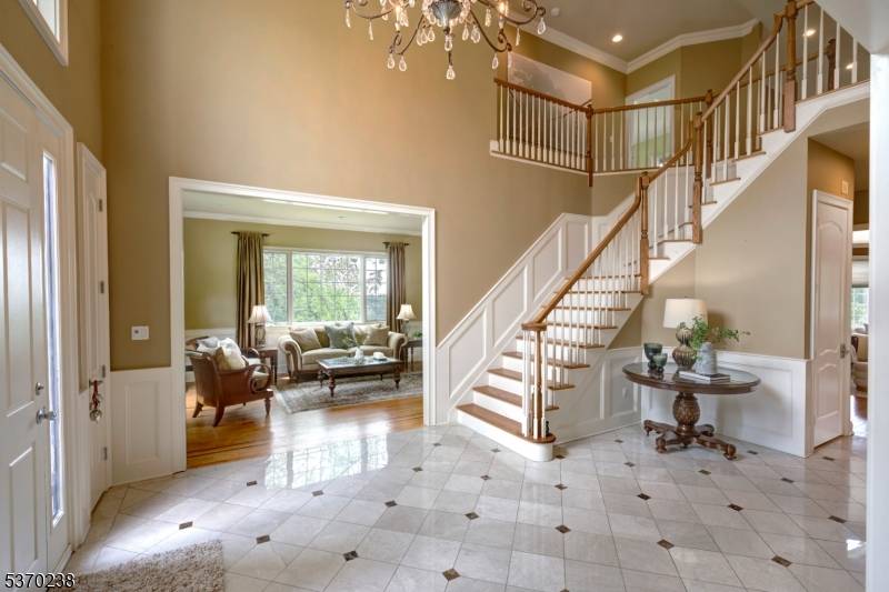 Welcome to 11 Trout Brook Court, where a tree lined driveway leads to a colonial with a two story foyer, revealing an open floor plan with distinct gathering spaces.
