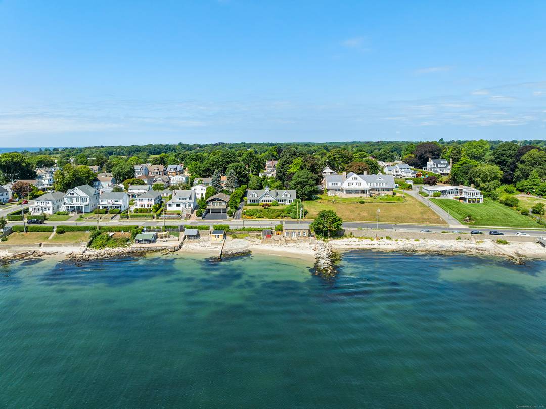 An enchanting New England home situated atop lush lawns with expansive panoramic water views overlooking a pageantry of sunrises, the beach, ocean views, sailboats, sea, sand, and iconic lighthouses with ...