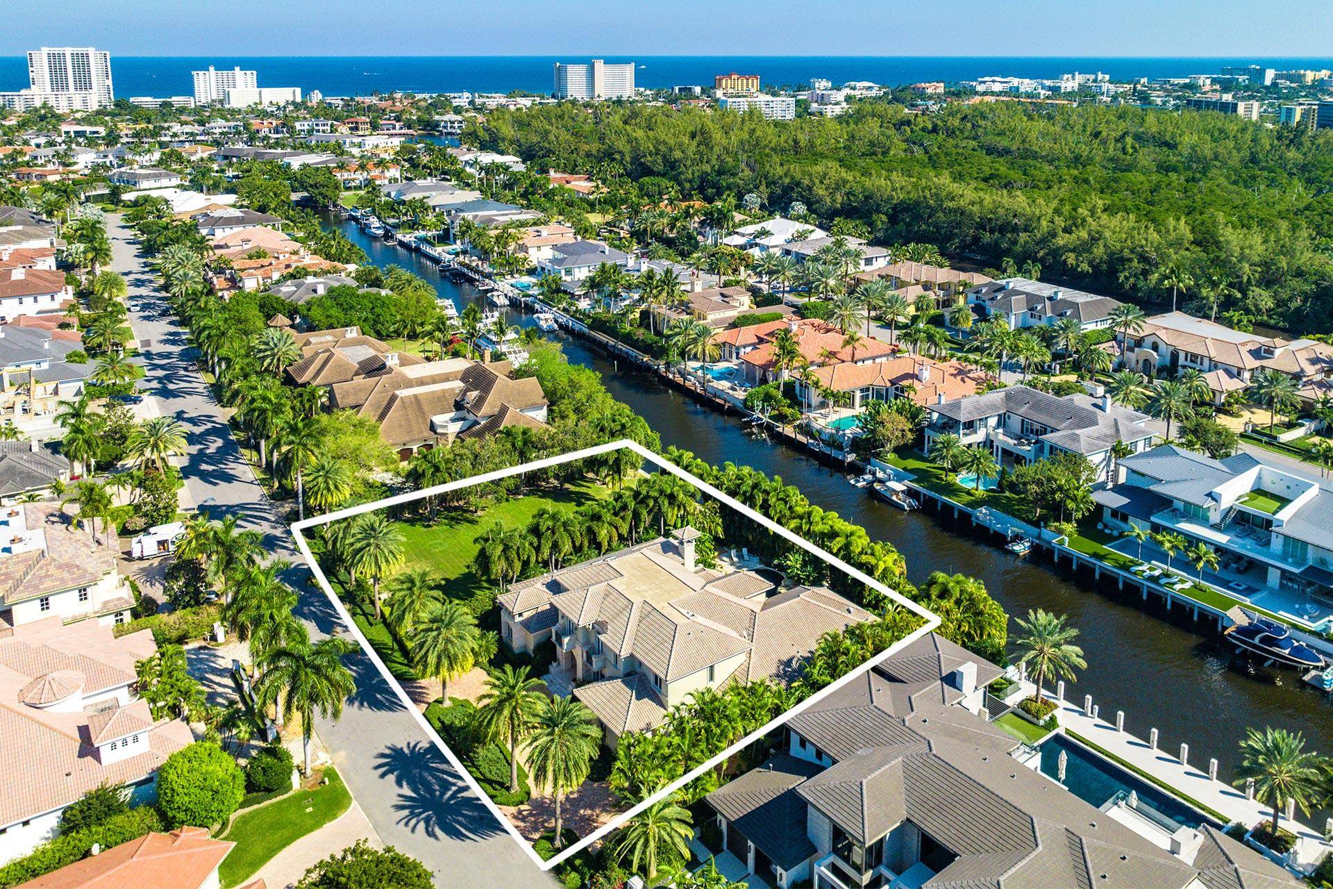 Immerse yourself in the unparalleled beauty of this exceptional waterfront estate, meticulously crafted in the prestigious Royal Palm Yacht Country Club.