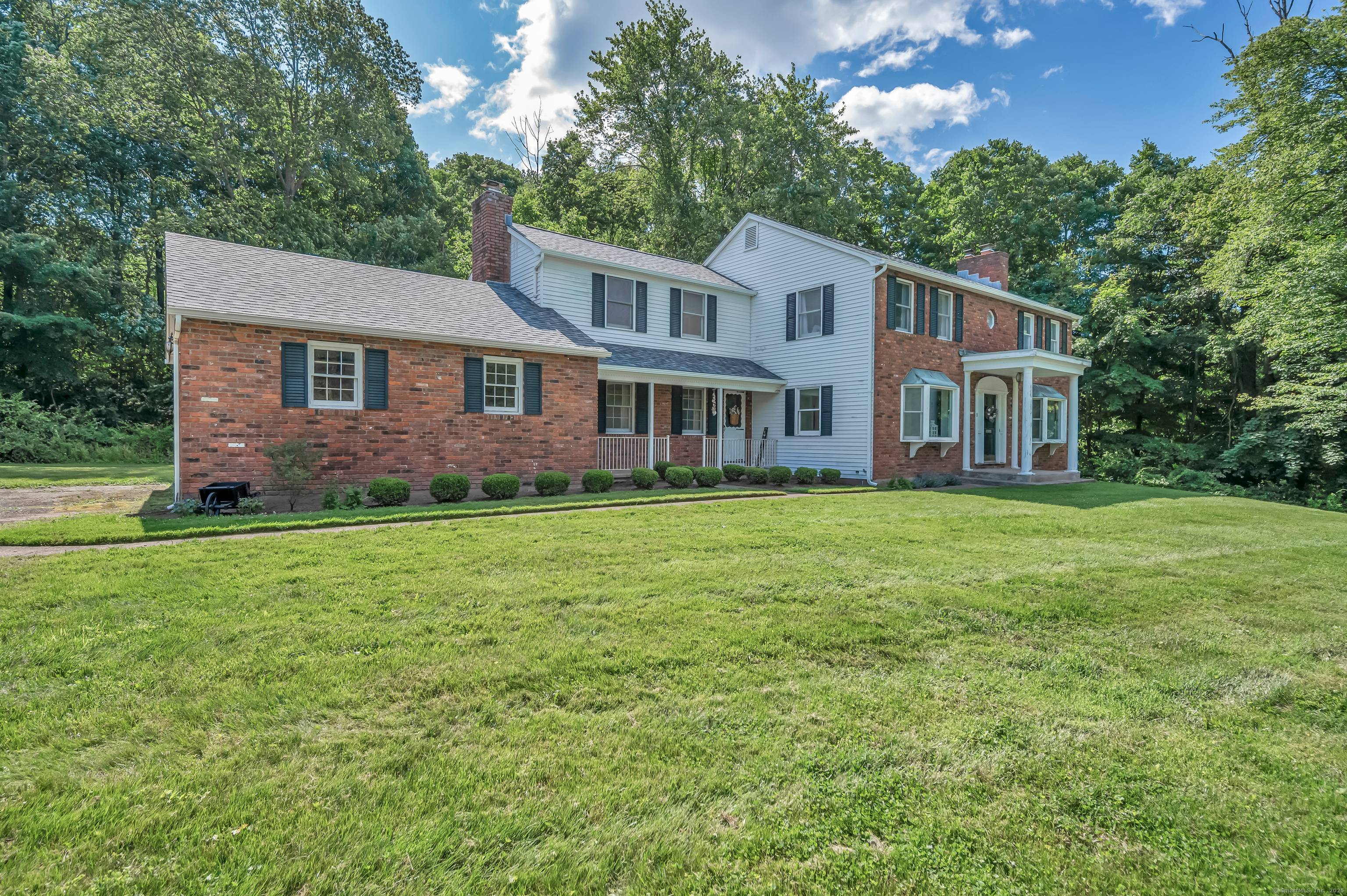 This classic colonial home features timeless charm with a stately brick front and elegant white pillar entryway.