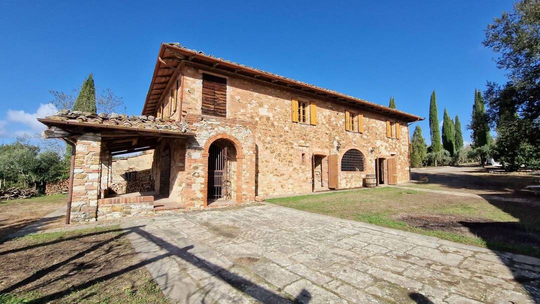 Country house with panoramic views, garden, park and three annexes for sale in Asciano, Tuscany.