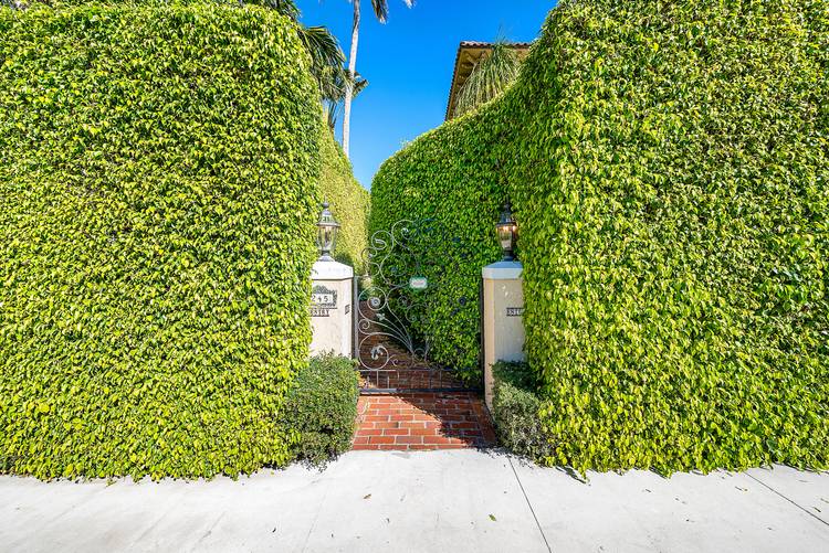 Quintessential Palm Beach living tucked behind lush hedges in a coveted island setting.