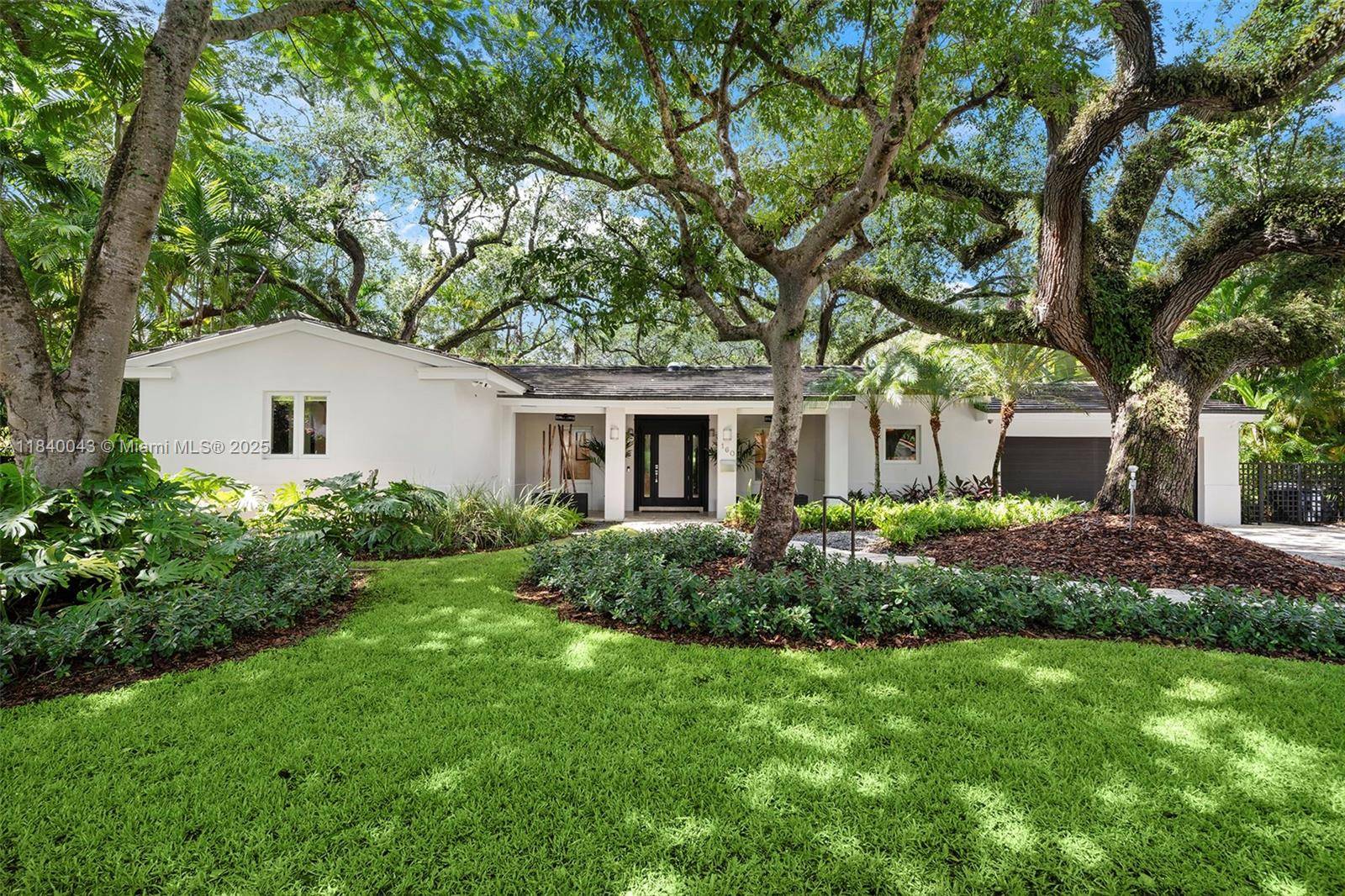 Situated at the top the ridge beneath a canopy of majestic oak trees, this completely updated Coral Gables home artfully blends sophistication with casual Miami living.