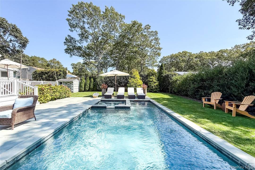 Step into the light filled living room, seamlessly connected to a cozy lounge area by a fireplace perfect for relaxation after a day in the sun.