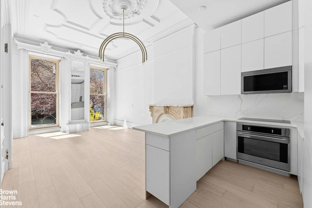 Step through original double parlor doors into soaring 13 foot ceilings, massive southwest facing windows, and the kind of pre war detail that simply can't be replicated including a decorative ...