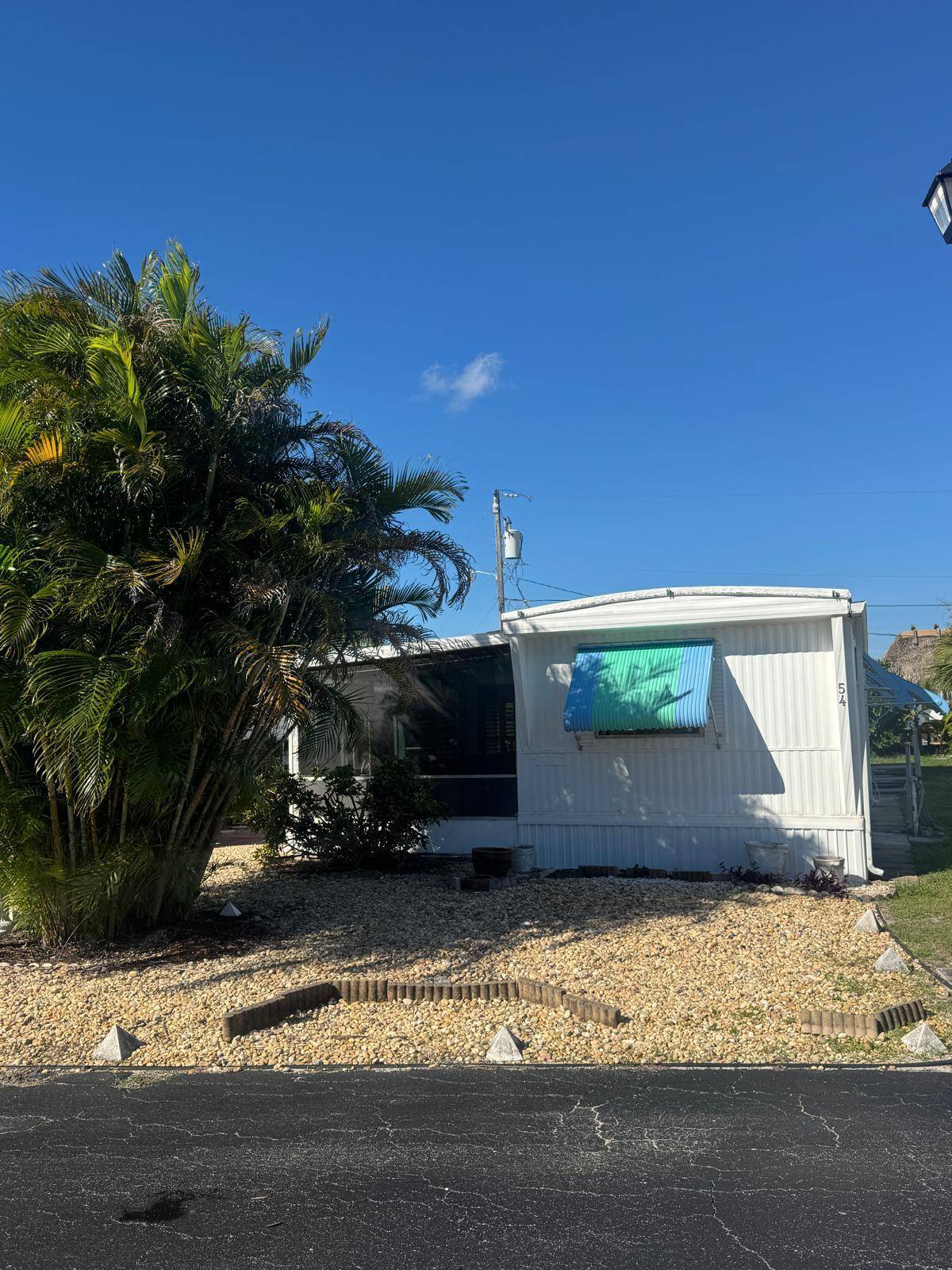 Spacious well kept expanded singlewide in Woodbridge Mobile Manor Co Op, 55 community in Hobe Sound.