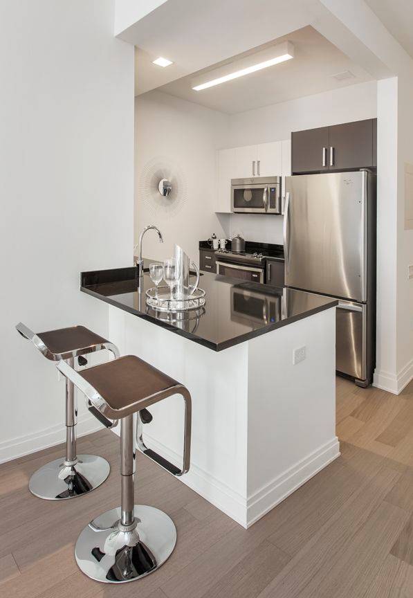 One bedroom features a spacious living room, gourmet kitchen with stainless steel appliances, stone countertops, high ceilings, multiple closets, in unit washer dryer, and wood floors throughout.