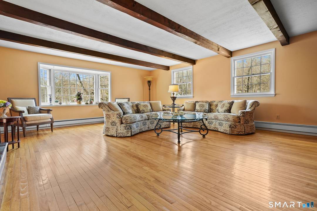 Located in a prime Ridgefield location Welcome to this spacious and well maintained 4 bedroom, 3 bath ranch set on a private, wooded acre on desirable Flat Rock Drive.