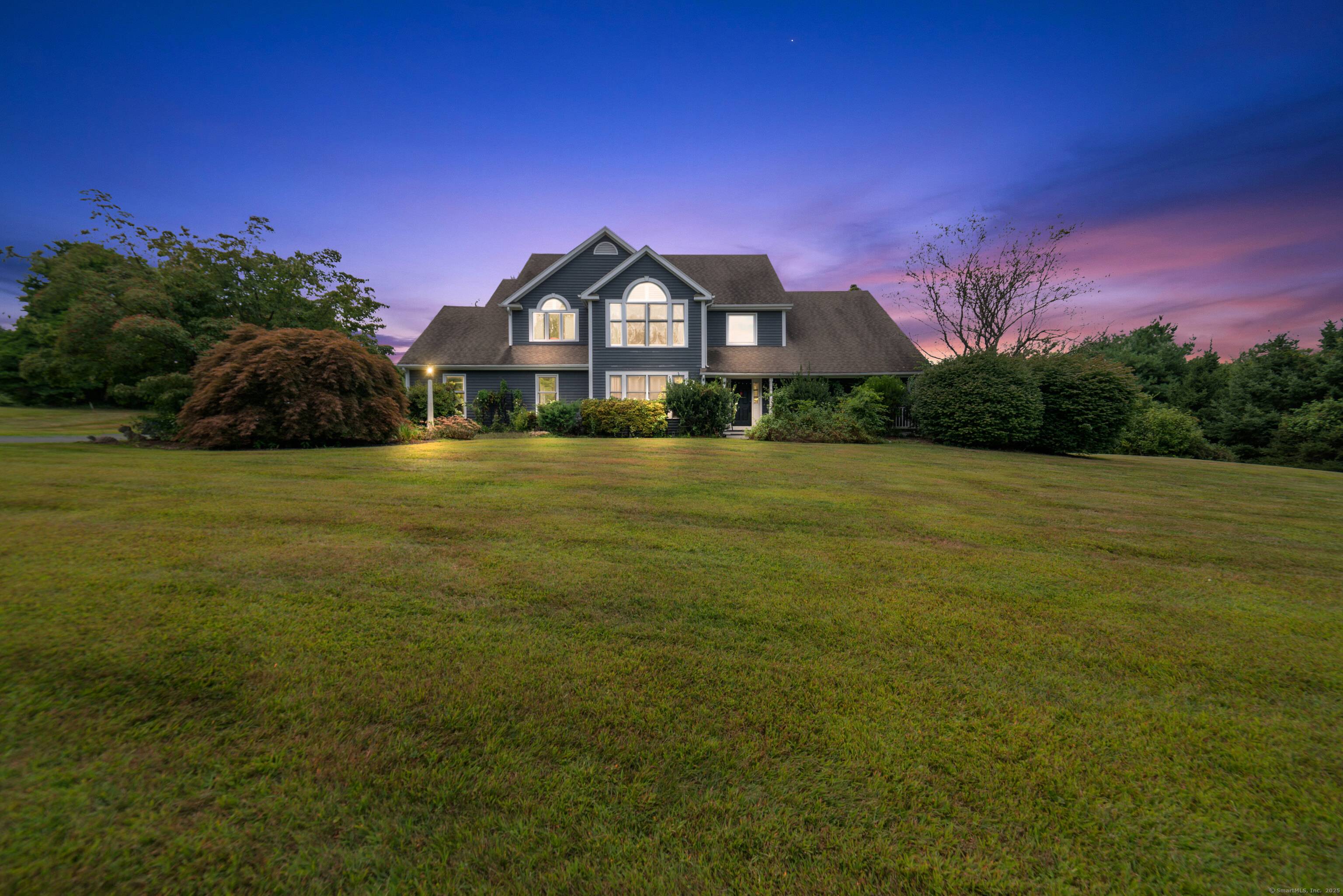 Located in a rural area within Newtown, Connecticut, this colonial home sits on a level, cleared corner lot.