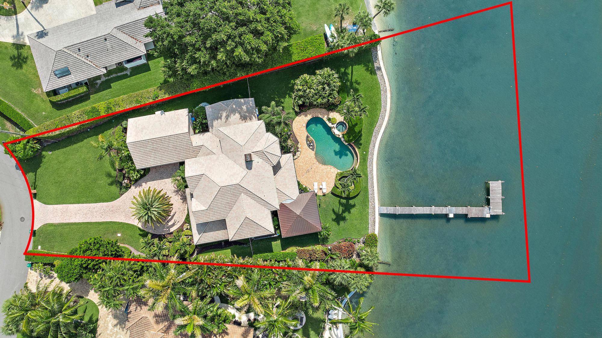 Located in Tequesta Country Club, on an oversized lot, this stunning two story waterfront home sits on nearly half an acre with over 130' of wide waterfrontage.