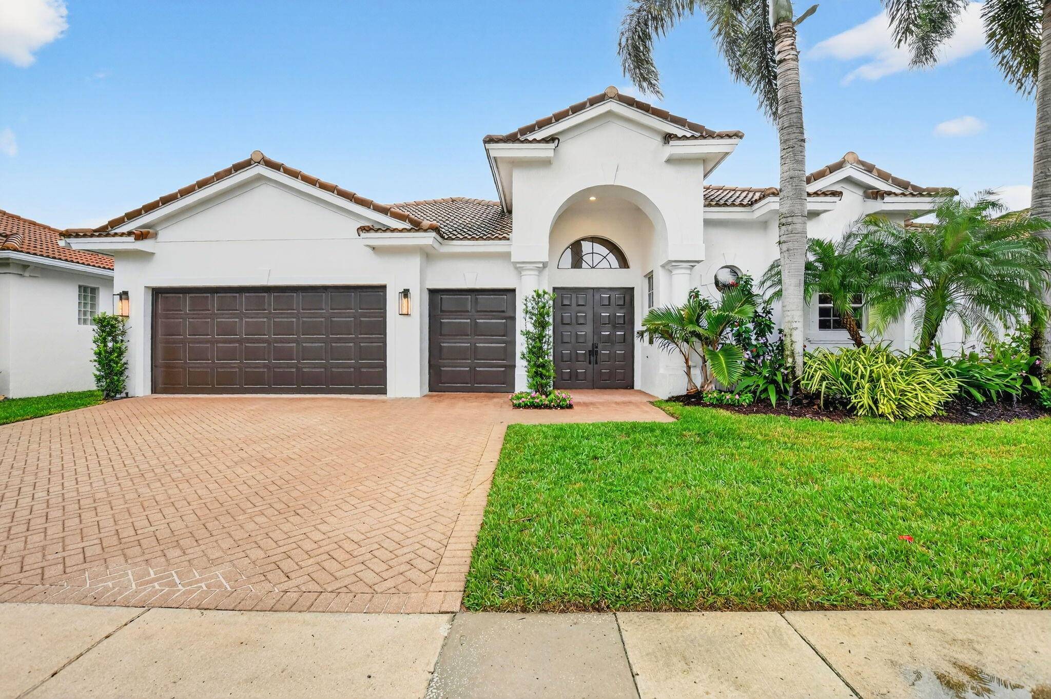 Stunning courtyard home in Mizner Country Club offering immediate golf membership with serene lake and golf views.