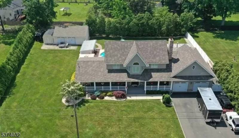 Expansive lemonade porch welcomes you to a backyard paradise featuring a saltwater gunite pool, cozy fire pit, tranquil stone water garden, and a fully equipped cabana ?