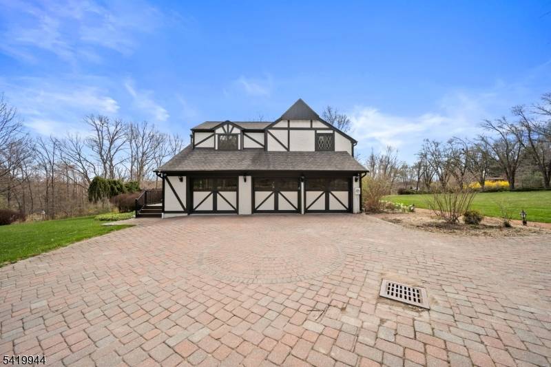 Welcome to this extraordinary Tudor Colonial set on three private acres, offering four levels of elegant living space.