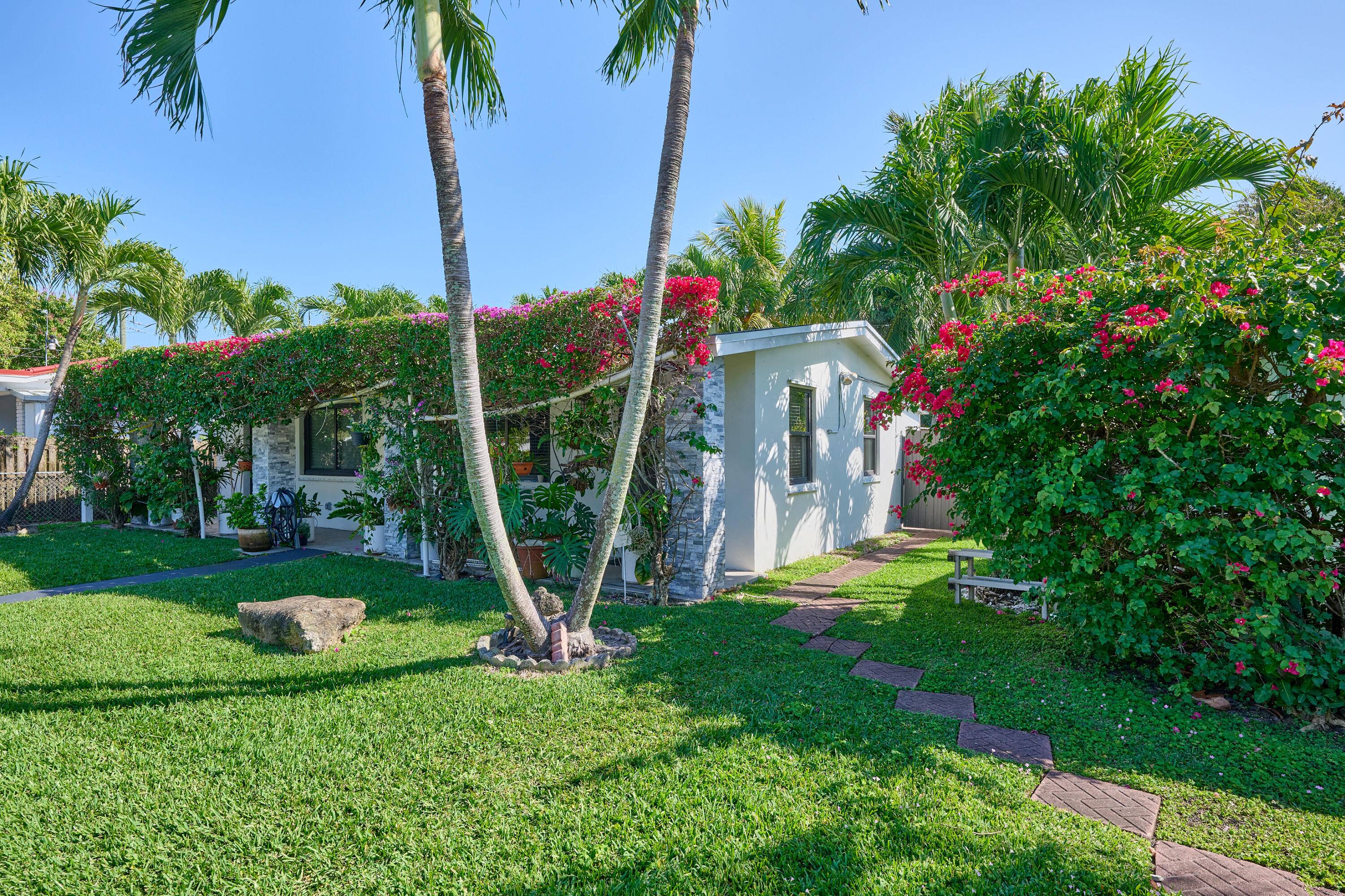 This duplex boasts a beautiful front yard, parking for four, and a spacious backyard perfect for outdoor living.