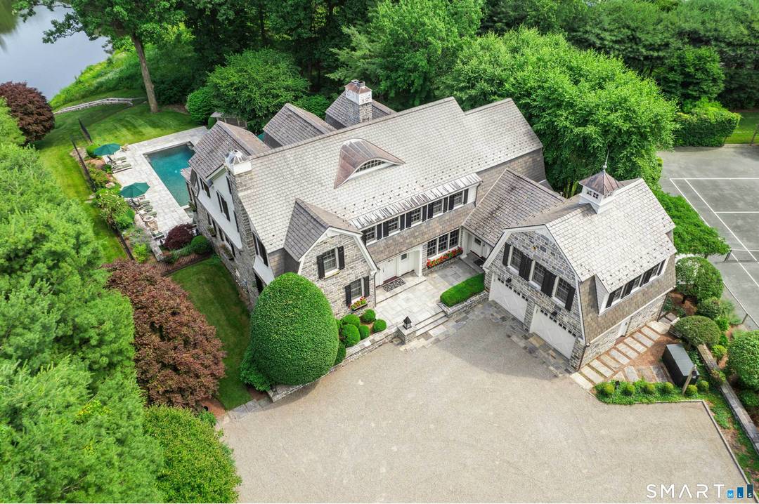 Experience timeless elegance and resort style living in this extraordinary stone estate on 2 spectacular acres overlooking a serene spring fed pond with direct water access.