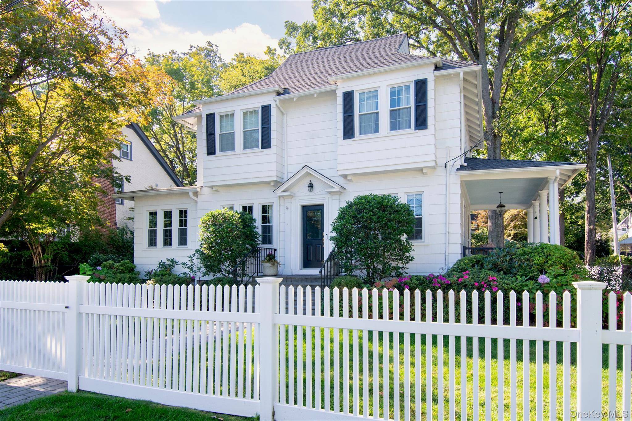 A movie set setting ! This stunning white Colonial sits on beautiful corner lot fenced in with white picket fencing and new landscaping.