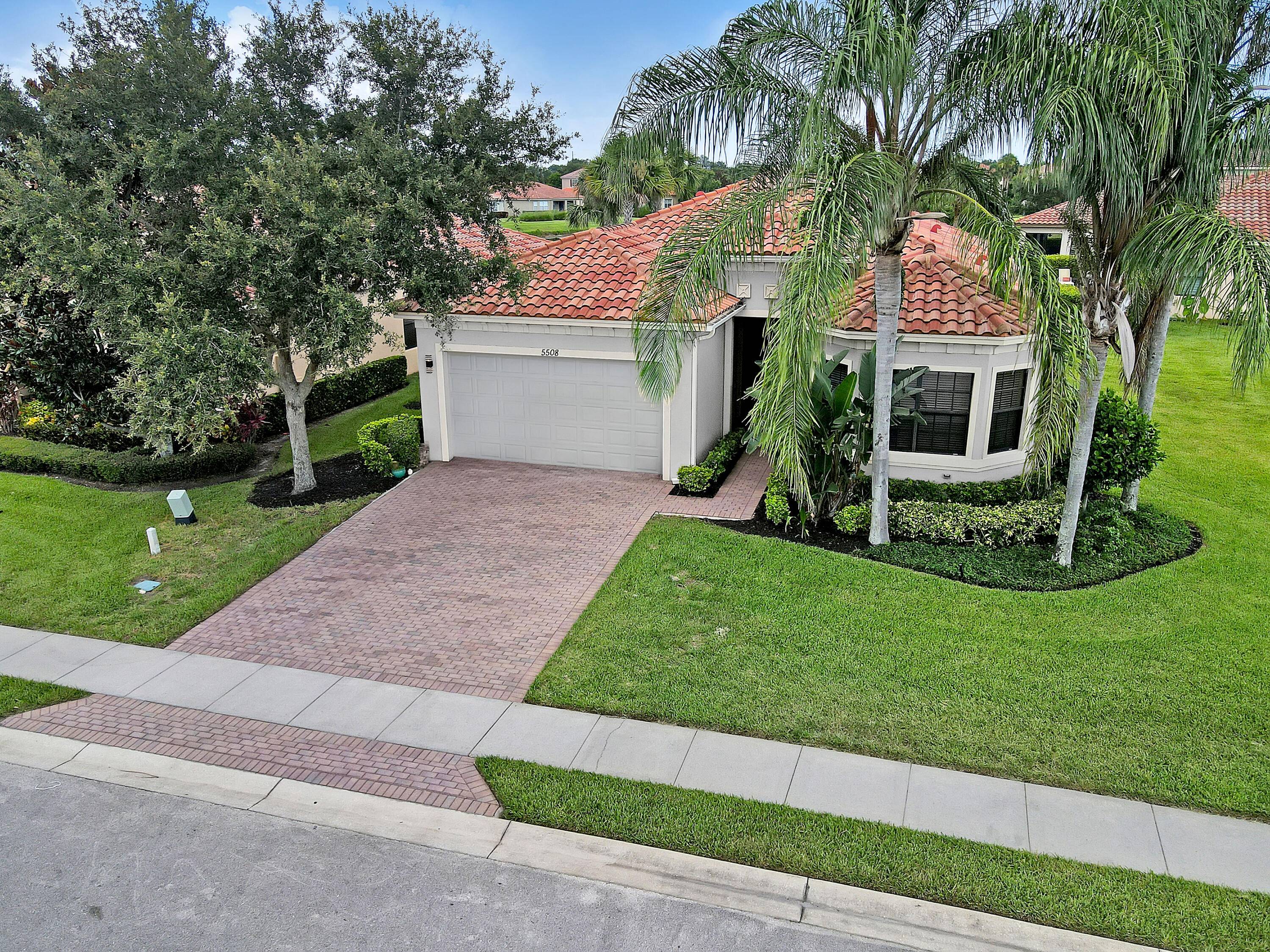Captivating Mediterranean style home on a corner lot with peaceful LAKE VIEWS in the gated community of VeroLago.