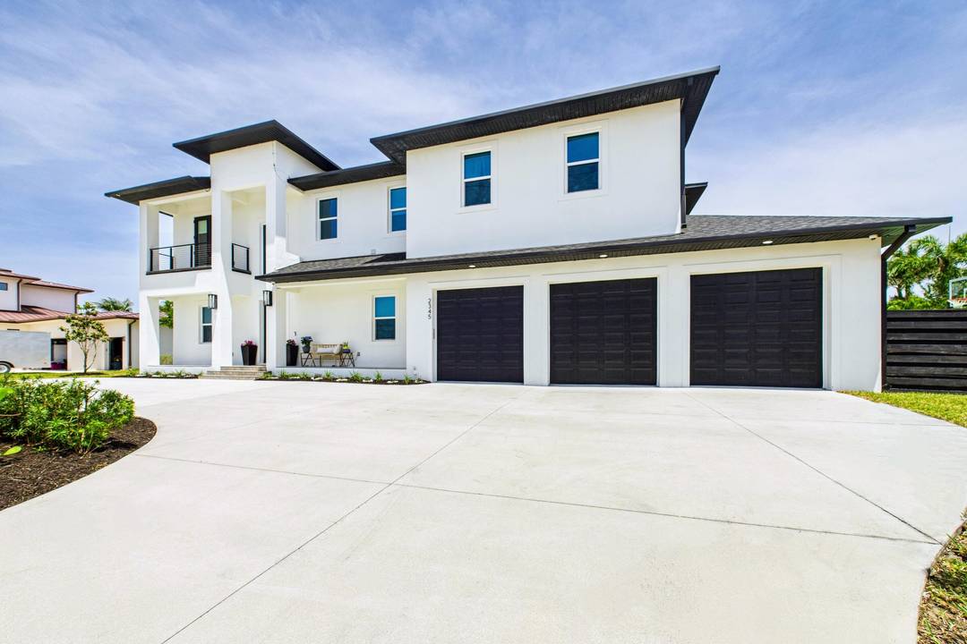 THIS 2022 contemporary is a STUNNER she offers sky high ceilings, marble tile floors, and a dramatic stacked stone fireplace in a sunlit great room.