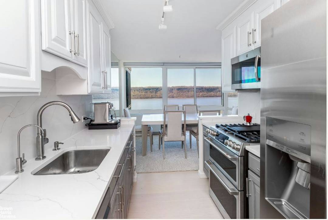 A wall of windows spanning the living and dining room magnificently frames the unobstructed views of the Hudson River, the Palisades and beyond.