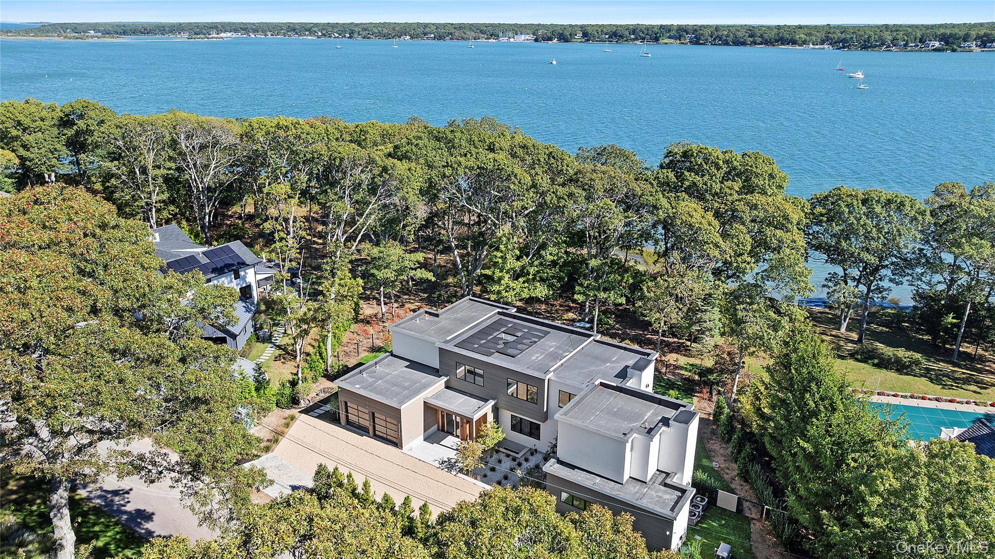Newly completed and design driven, this waterfront home makes a bold statement in modern coastal living on a private acre with 140 feet of frontage.
