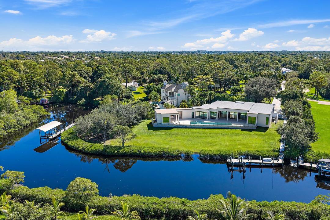 Newly completed in 2025, this exceptional waterfront estate sits on over two private acres along the North Fork of the Loxahatchee River.