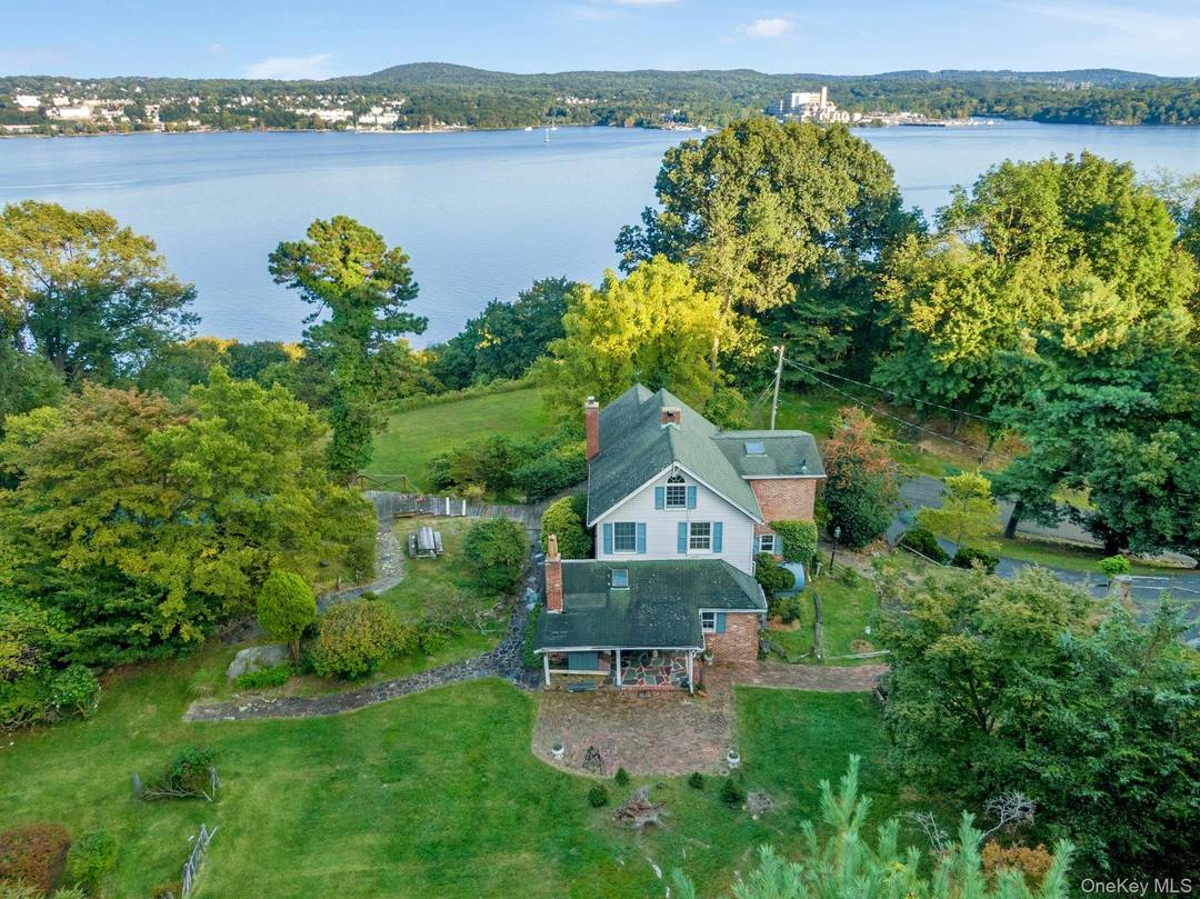 Whispering Pines is a turn of the century home with stunning Hudson River views on three acres of rolling lawns, mature plantings, and a natural, stone carved pool.