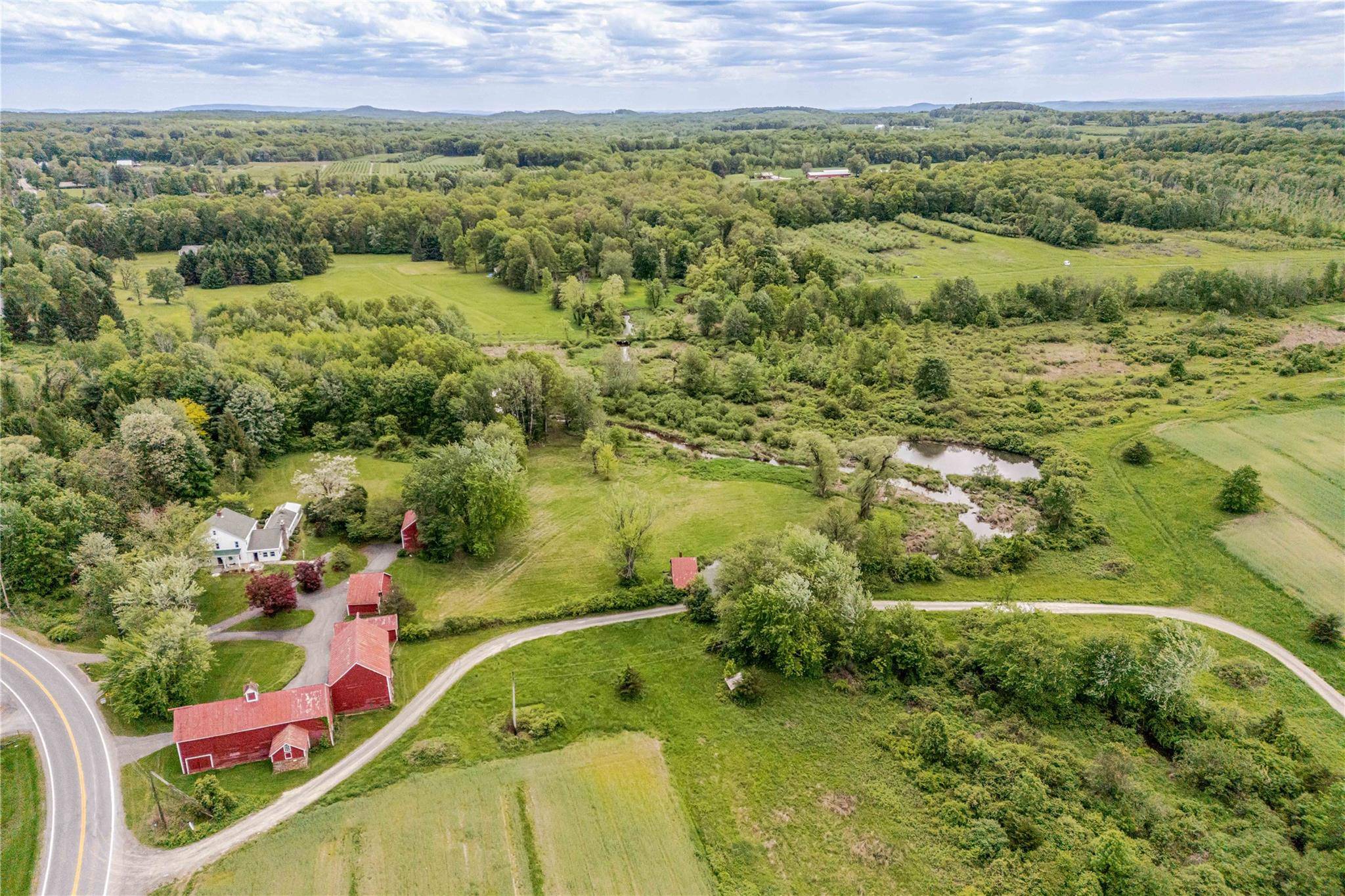 Welcome to Plattekill Brook Farm, a charming 1940 farmhouse featuring four classic barns, creek frontage, and panoramic views of the Shawangunk Ridge.