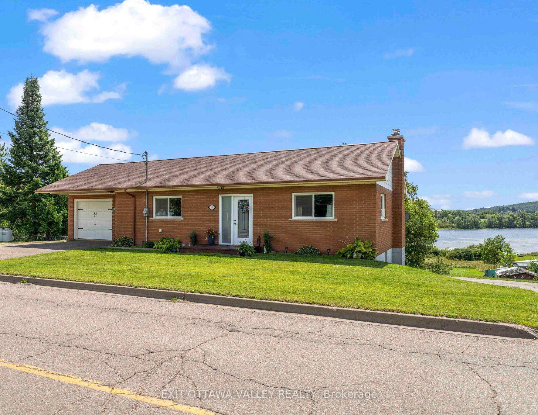 Discover the incredible potential of this solid brick bungalow, ideally situated on an ACRE of prime waterfront along the scenic shores of Kamaniskeg Lake.