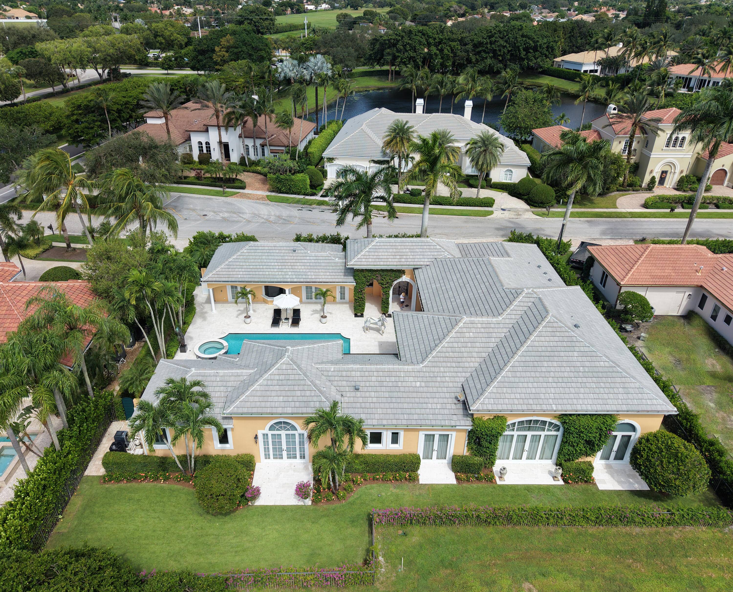 This Mizner Estates home with Southern exposure offers a timeless courtyard design, refined landscaping, and a prime location near the West Gate.