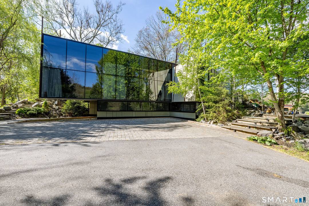 Step into summer at this incredible home, where modern design meets nature's tranquility.