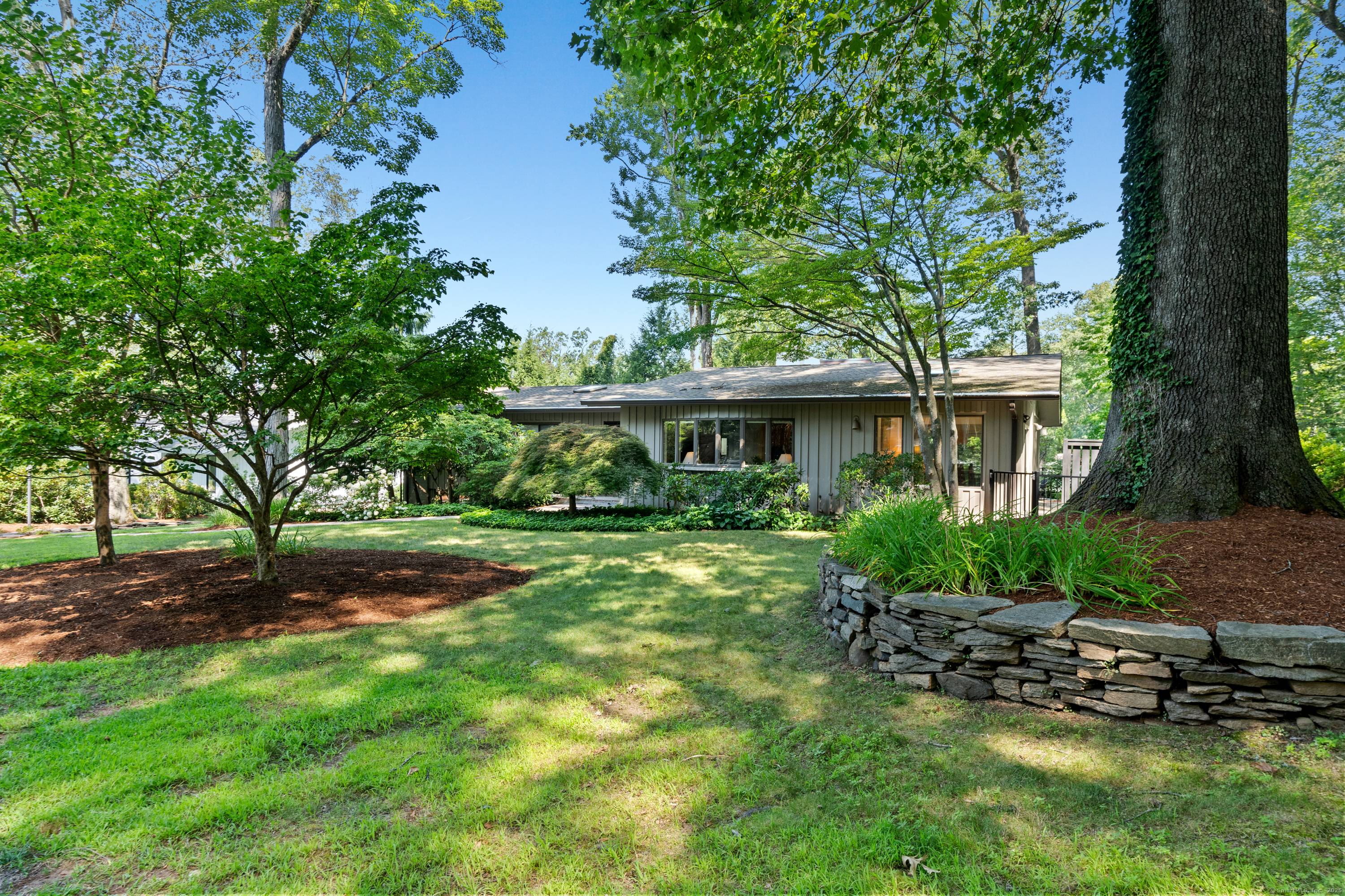 Nestled on a serene and secluded lot, this stunning mid century modern ranch offers the perfect blend of style, comfort, and connection to nature.