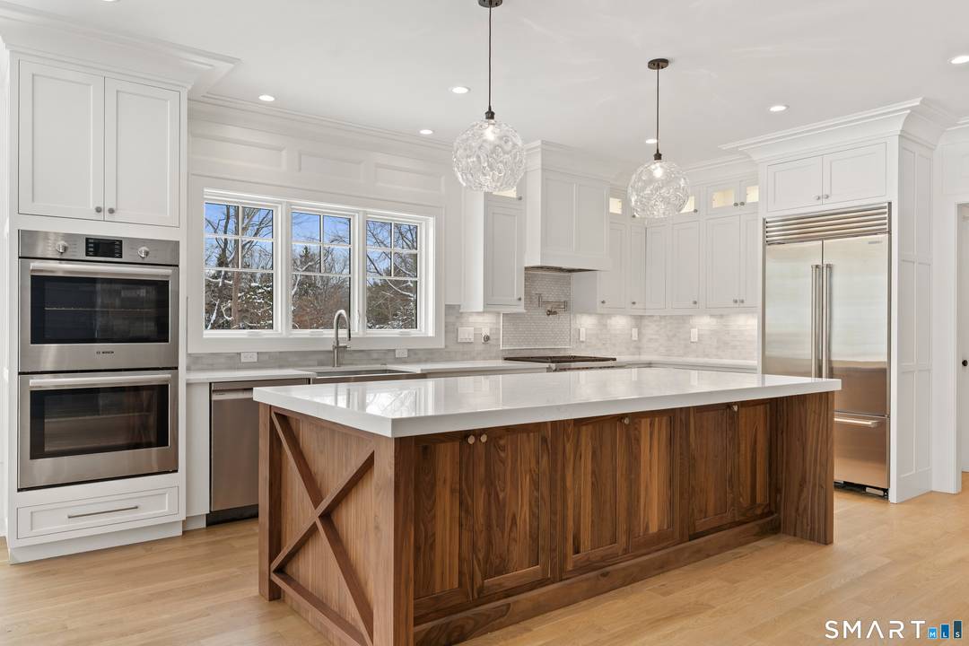 Less than one mile from downtown Madison, this new construction home offers refined living with white oak floors, custom millwork, coffered ceilings, and abundant natural light throughout.
