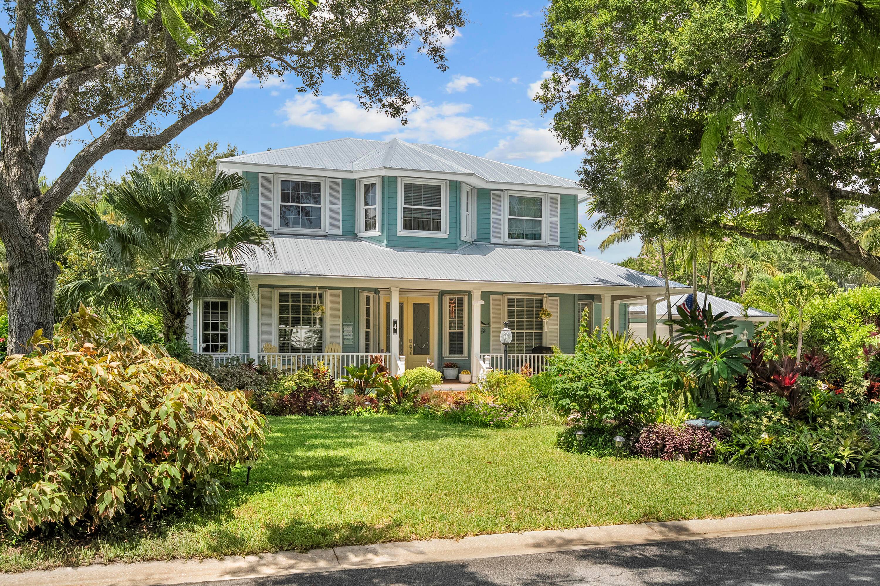 Nestled on a private, tree lined street in Sewall's Point, this charming 4 bedroom den, Key West style home offers a perfect blend of comfort and tropical elegance.