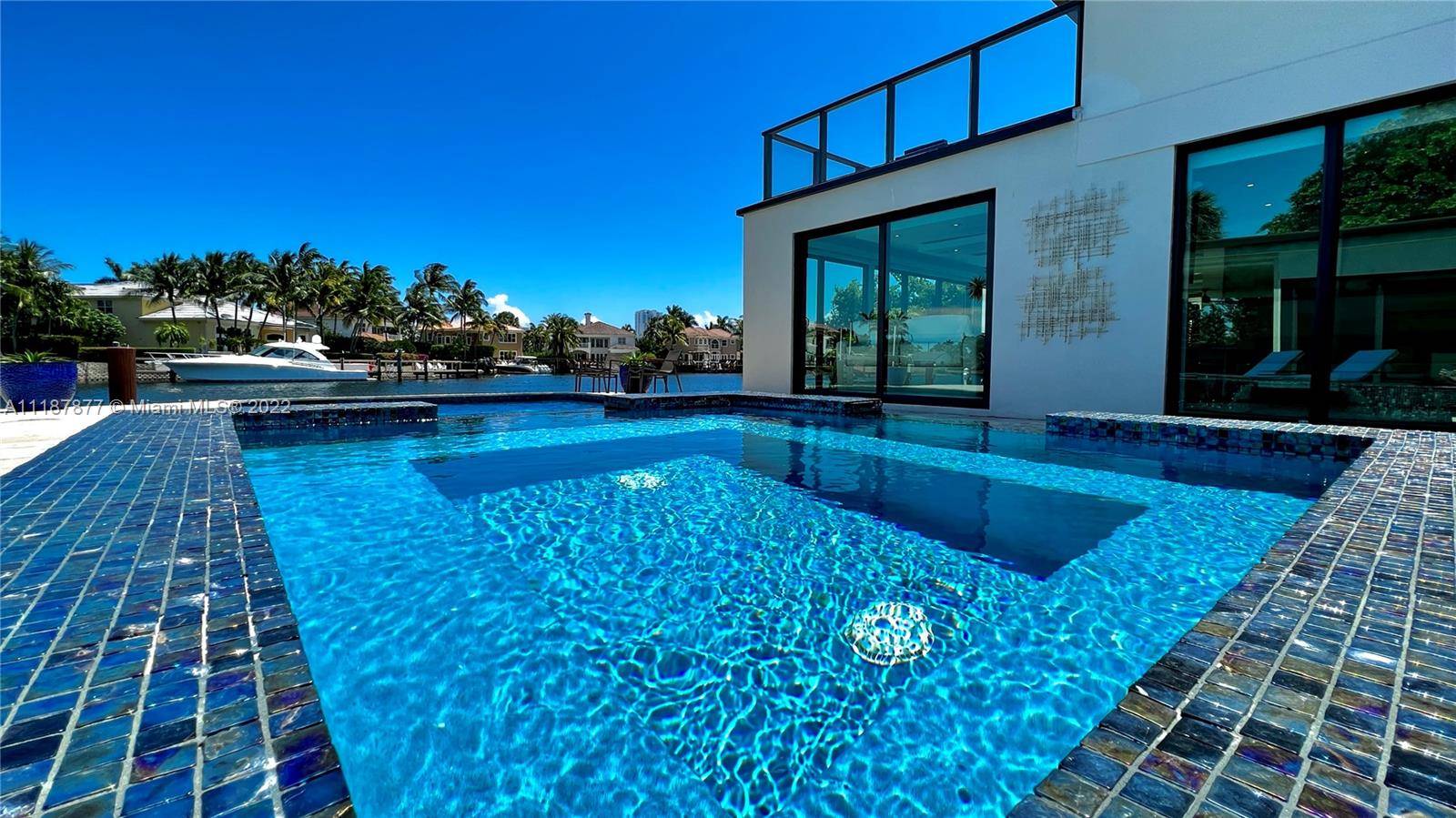 This stunning, modern waterfront mansion overlooks a wide water frontage of 90 feet views and features a private dock with boat lift.