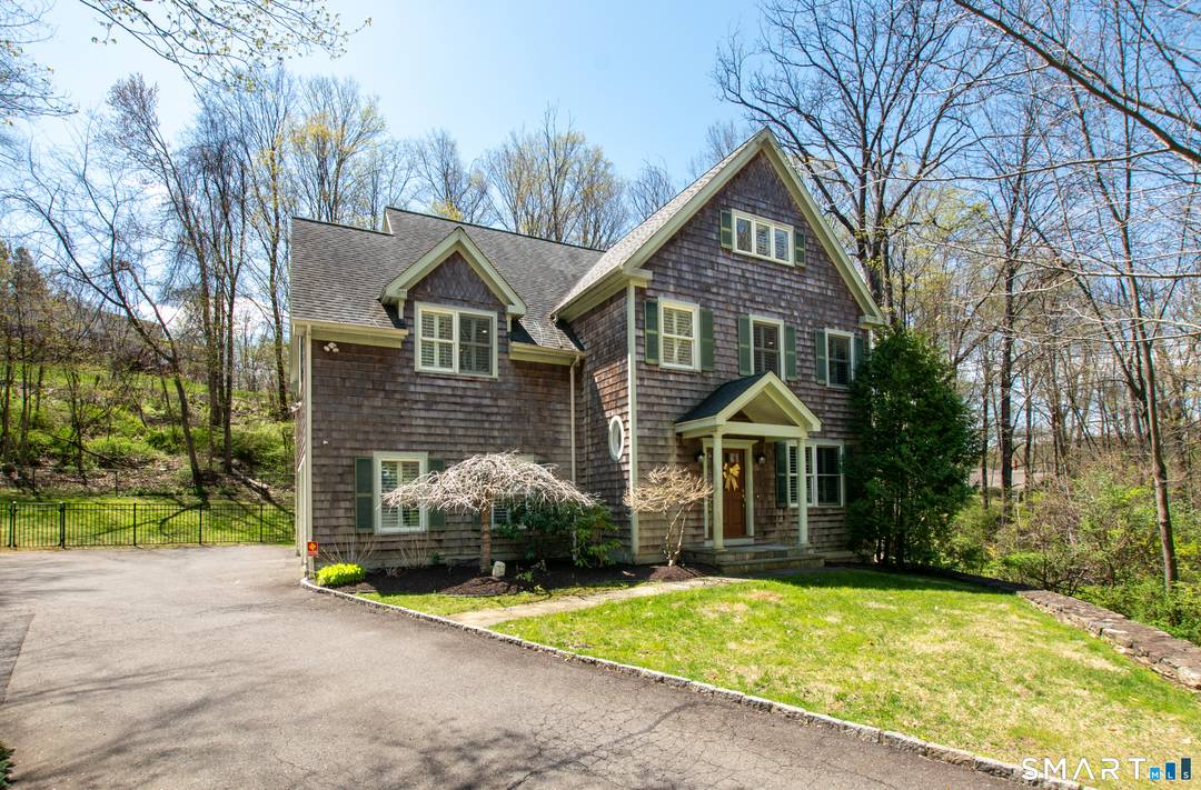 Set on a picturesque property with a private bridge over the Titicus River, this stunning cedar shake Colonial offers exceptional craftsmanship, modern updates, and seamless indoor outdoor living.
