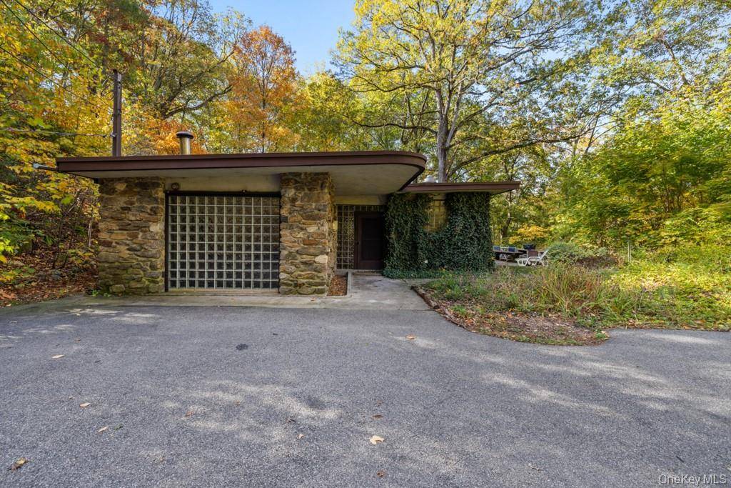 Set on more than 4 serene wooded acres, this architectural gem offers a rare combination of privacy and accessibility, just an hour from NYC.