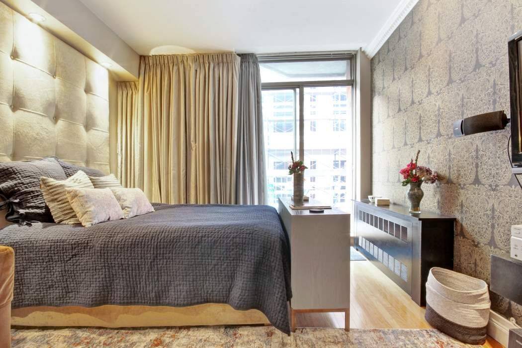 Quintessential Greenwich Village designer furnished studio with a balcony that floats above the treetops, offering views of the Empire Statement Building, Washington Square Park, and the iconic Village skyline.