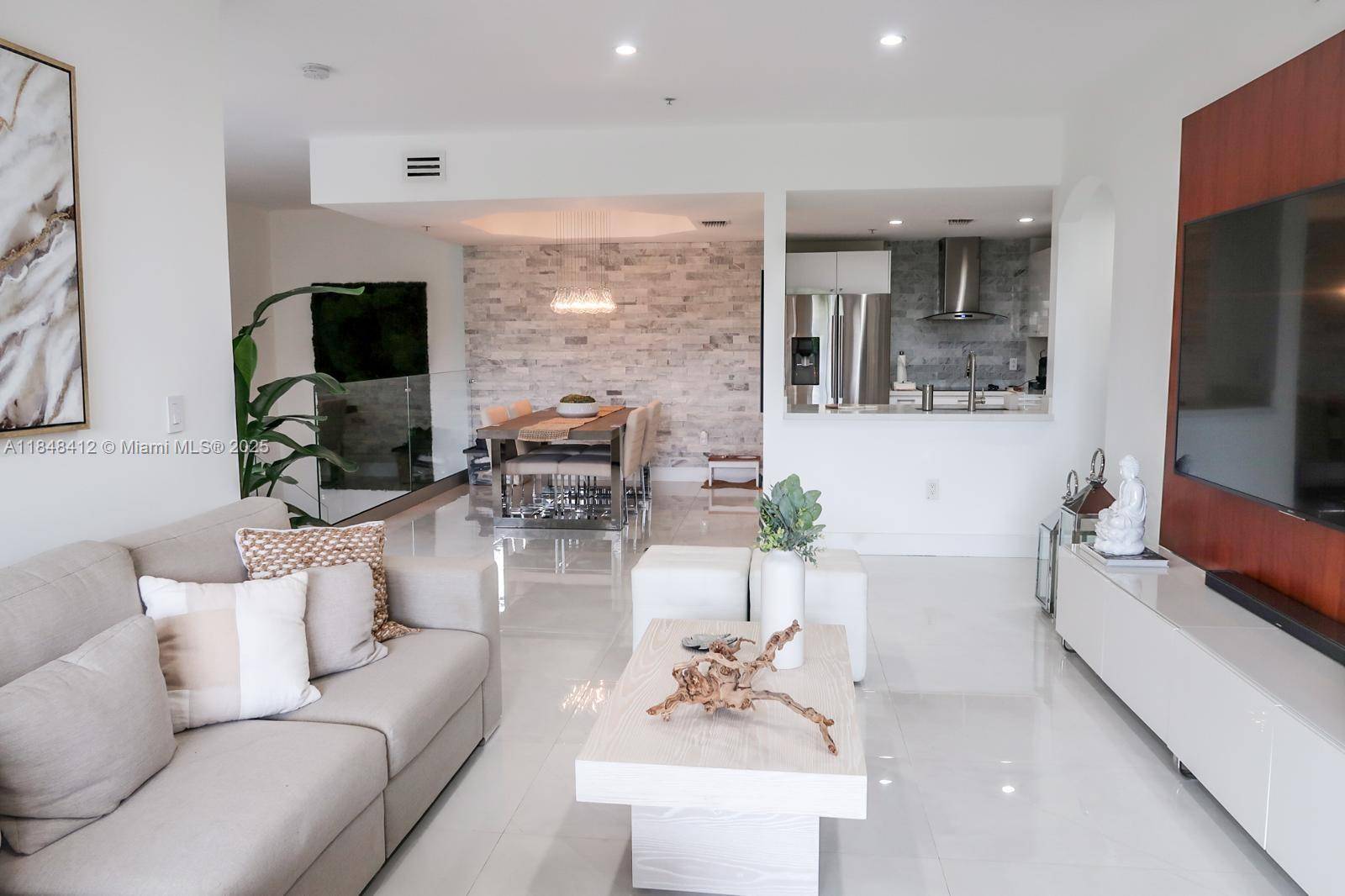 Step into this beautifully remodeled 3 bedroom, 2 bath apartment featuring white porcelain floors, a sleek modern kitchen with elegant stone style countertops, and stainless steel appliances.