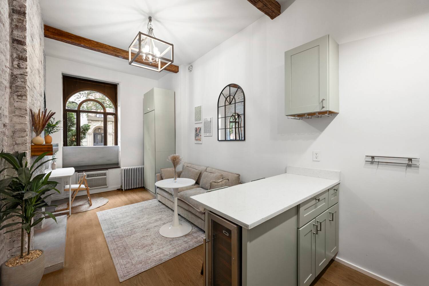 Barn doors, soaring ceilings, arched windows, exposed brick, and muted sage.