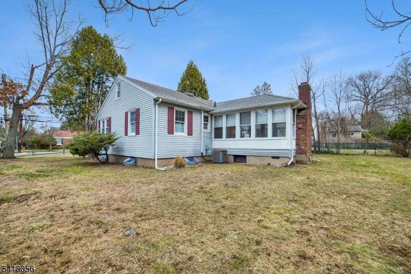 Sunny corner ranch with stone and vinyl siding exterior on nearly quarter acre lot.