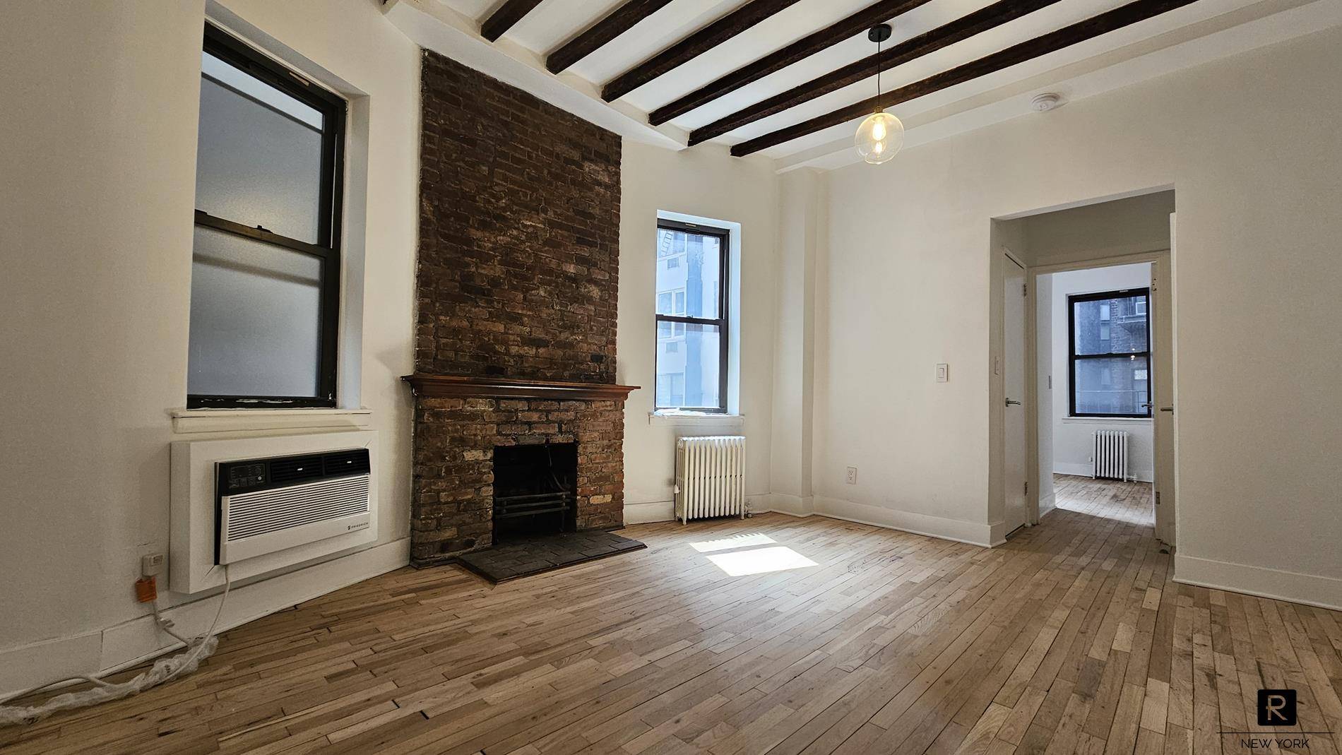 The charming and cozy 1BR 1Bath pre war Co op, 11ft high beamed ceilings with a wood burning fireplace exposed brick.