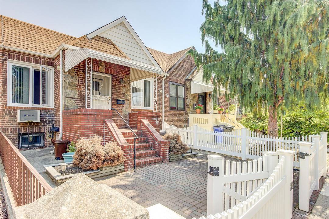 Charming single family attached home on a beautiful rowhouse block in Middle Village North.