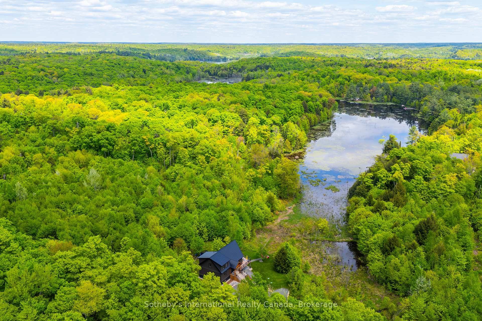 Nestled in Muskoka Lakes, this stunning property spans approximately 20 acres of lush, forested land, complete with an incredible lookout over a serene pond.